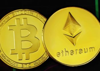 Two shiny cryptocurrency coins on a dark background