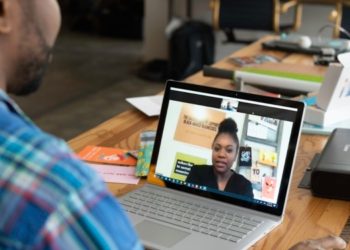 Two colleagues engage in a focused virtual meeting, discussing strategies for implementing knowledge management to enhance efficiency within a manufacturing company.