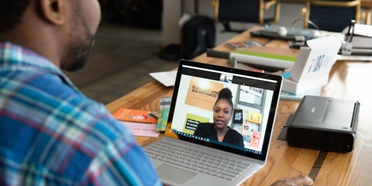 Two colleagues engage in a focused virtual meeting, discussing strategies for implementing knowledge management to enhance efficiency within a manufacturing company.