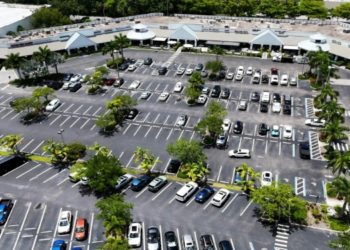 Aerial view of a parking lot with different parked cars