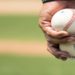 Close-up of a person holding two baseballs