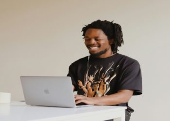 Man in black crew neck t-shirt using macbook