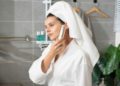 Woman wearing a bathrobe in a casual and comfortable bathroom setting.