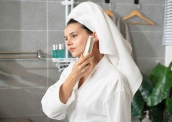 Woman wearing a bathrobe in a casual and comfortable bathroom setting.