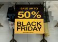 Black Friday sale sign displayed in a store window, featuring bold text and eye-catching colors to attract shoppers.