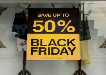 Black Friday sale sign displayed in a store window, featuring bold text and eye-catching colors to attract shoppers.