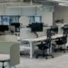 Modern office interior with several desks and ergonomic chairs for employees.