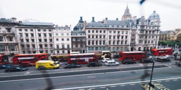 Looking out from a window at a vibrant UK city street, with vehicles and people navigating the urban landscape.