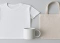 White T-shirt, plain mug, and beige tote bag are arranged on a light gray background. The minimalistic style conveys simplicity and calmness.
