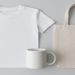 White T-shirt, plain mug, and beige tote bag are arranged on a light gray background. The minimalistic style conveys simplicity and calmness.