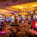 Vibrant casino interior with rows of colorful slot machines, plush carpeting, and chandelier lighting, creating an energetic and inviting atmosphere.