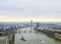 Aerial view of London shows Thames River, bridge, and cityscape with modern and historic buildings