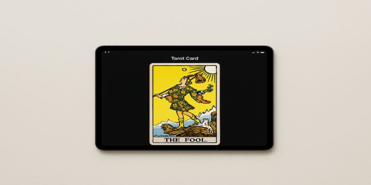 Tarot card depicts "The Fool" on a tablet screen. The card illustrates a carefree figure near a cliff, under a bright yellow sky, evoking a sense of adventure.