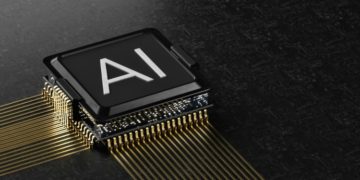 Microchip with the letters "AI" is resting on a dark, textured surface. Gold circuit lines extend from the chip, portraying a high-tech, futuristic feel.