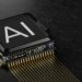 Microchip with the letters "AI" is resting on a dark, textured surface. Gold circuit lines extend from the chip, portraying a high-tech, futuristic feel.