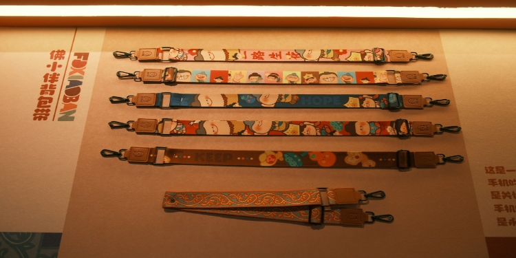 Display of seven colorful lanyards with cartoon designs and clips, laid horizontally on a lit surface. The mood is playful and vibrant.