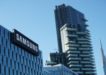 Modern cityscape with a Samsung building in the foreground, a tall residential tower, and additional skyscrapers against a clear blue sky.