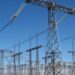 High-voltage switchgear and overhead lines at an electrical substation under a blue sky