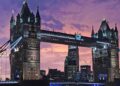 Tower Bridge in London lit up at dusk under a purple sky