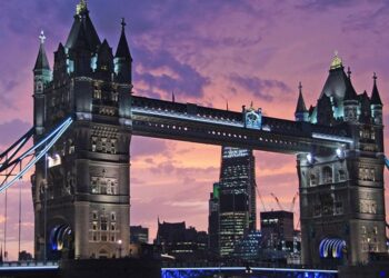 Tower Bridge in London lit up at dusk under a purple sky
