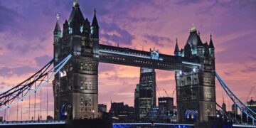 Tower Bridge in London lit up at dusk under a purple sky