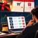 Trader at a desk comparing discounted prop firm challenge offers on a laptop, with Black Friday sale tags, calendars and trading charts