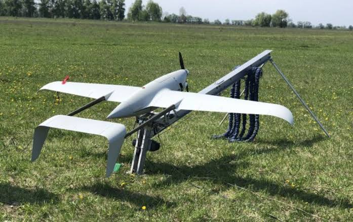 Skyeton Raybird drone on its launch catapult in a grass field