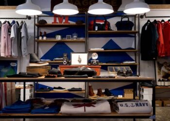 Clothing and accessories displayed on shelves in a small retail store