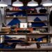 Clothing and accessories displayed on shelves in a small retail store